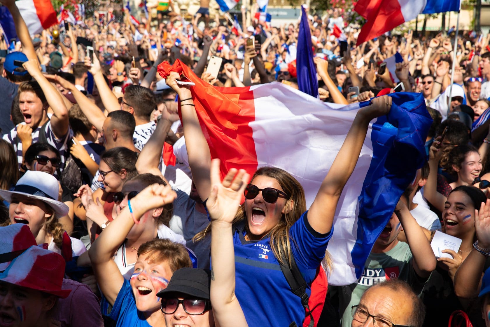 beaucoup de personnes avec le drapeau français et du maquillage au couleur du drapeau sont rassemblés sur la place carnot