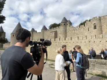 une interview du créateur du jeu Carcassonne se prépare devant la cité médiévale